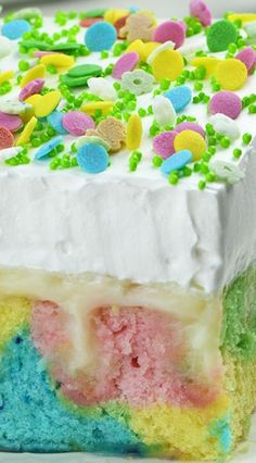 a slice of rainbow cake with white frosting and sprinkles