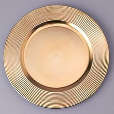 an empty gold plate on a gray background