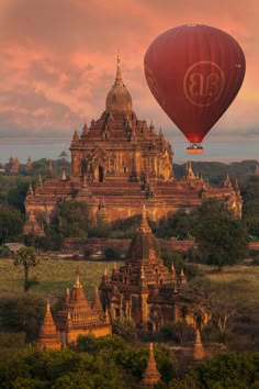 a hot air balloon flying over a large building with many spires in the sky