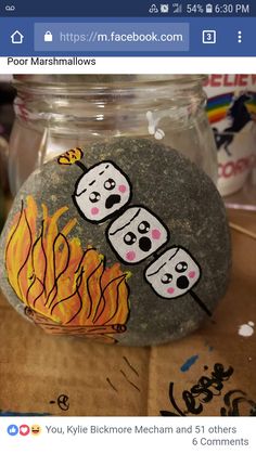 a glass jar with some rocks painted on it