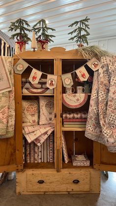 a wooden cabinet filled with lots of fabric and christmas decorations on top of it's sides