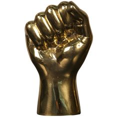 a gold fist - like statue is shown against a white background