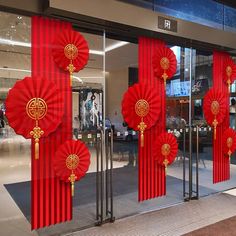 red and gold decorations are on display in front of a storefront window with glass doors