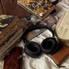 there are many books and headphones laying on the bed with it's contents