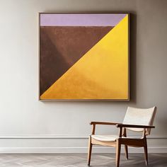 a chair sitting in front of a painting on the wall