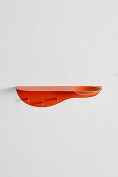 an orange shelf is hanging on the wall