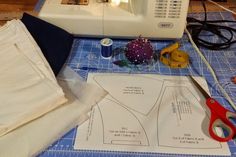 sewing supplies are laid out on a table next to a sewing machine, scissors and thread