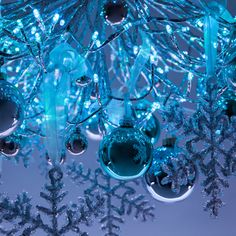 a chandelier with blue lights and snowflakes hanging from it's sides