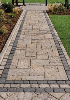 a brick walkway in the middle of a grassy area