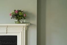 a vase with flowers sitting on top of a fireplace