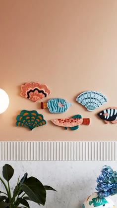 the wall is decorated with colorful fish and shell shapes, along with a plant in a vase