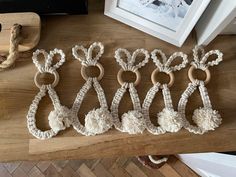 four wooden rings with white yarn hanging from them on a table next to a framed photograph