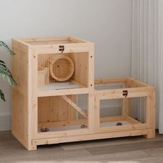 a wooden cage with a fan on top and a potted plant in the corner