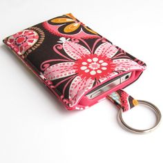 a pink and black flowered cell phone case with a keychain attached to it