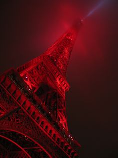 the eiffel tower is lit up in red