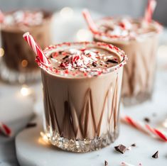 two glasses filled with hot chocolate and candy canes