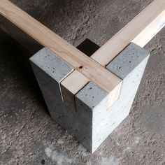 a close up of a cement block with a wooden beam sticking out of it's center