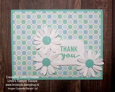 a thank card with white daisies and green polka dot paper on it, in front of a wooden background