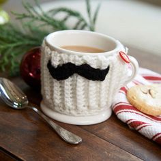 a knitted mug with a black mustache on it