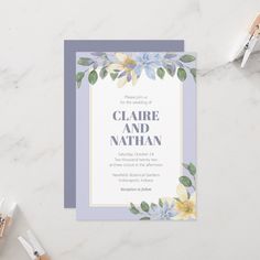 a wedding card with watercolor flowers and leaves on the front, in blue and yellow