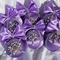 six purple ornaments with bows and jewels on them