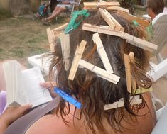 the back of a woman's head with pieces of wood stuck to her hair