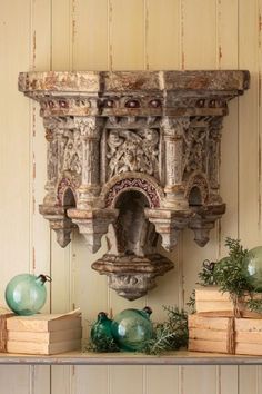 a shelf with books and vases sitting on it's sides, in front of a wall