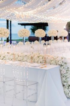 a table with white flowers and candles on it