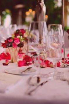 the table is set with flowers and wine glasses