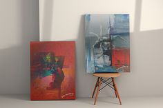 two paintings are shown next to each other on a chair in front of a white wall