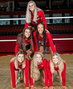 the cheerleaders are posing for a photo in their red outfits on the court