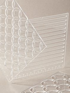 three clear acrylic sheets with circles and lines on the bottom one has a ruler in front of it