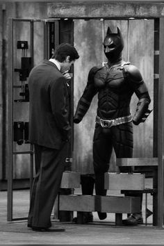 two men dressed as batman standing next to each other