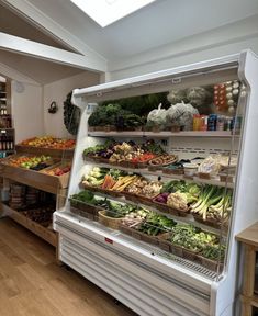 an open refrigerator filled with lots of fresh fruits and veggies in it's display case