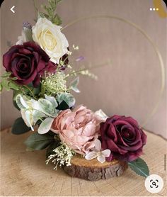 flowers are arranged on top of a piece of wood