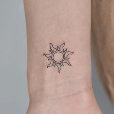 a small sun tattoo on the wrist