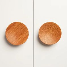 two wooden knobs on the side of a white cabinet