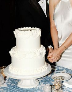 a bride and groom are cutting their wedding cake with the help of an elegant knife