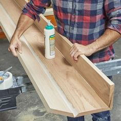 a man standing next to a table with some wood on it and glue in front of him