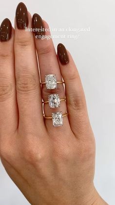 a woman's hand with three rings on her fingers and two diamonds in the middle