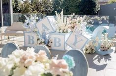 an outdoor wedding setup with flowers and letters on the ground, in front of some chairs