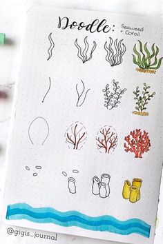 an open notebook with doodle drawings and watercolor pencils on top of it