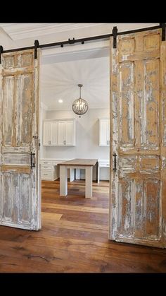 an open door leading to a kitchen and dining room in a house with wood floors