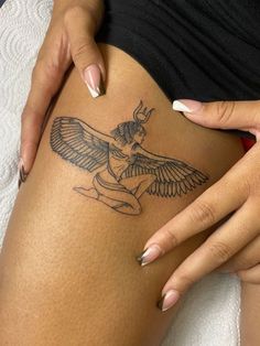 a woman is showing off her tattoo on her thigh