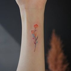 a small flower tattoo on the wrist