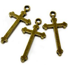 two bronze cross charms on a white background