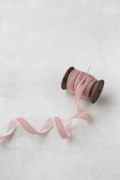 a spool of pink ribbon on a white surface