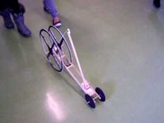 a person pushing a dolly with wheels on the floor