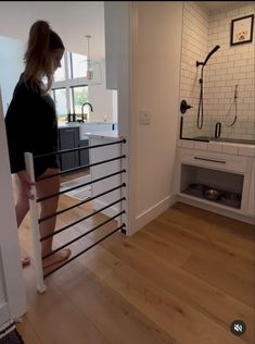 a woman is walking up the stairs in her home, looking at something on the floor