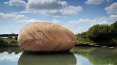 a large wooden boat floating on top of a lake under a cloudy blue sky with white clouds